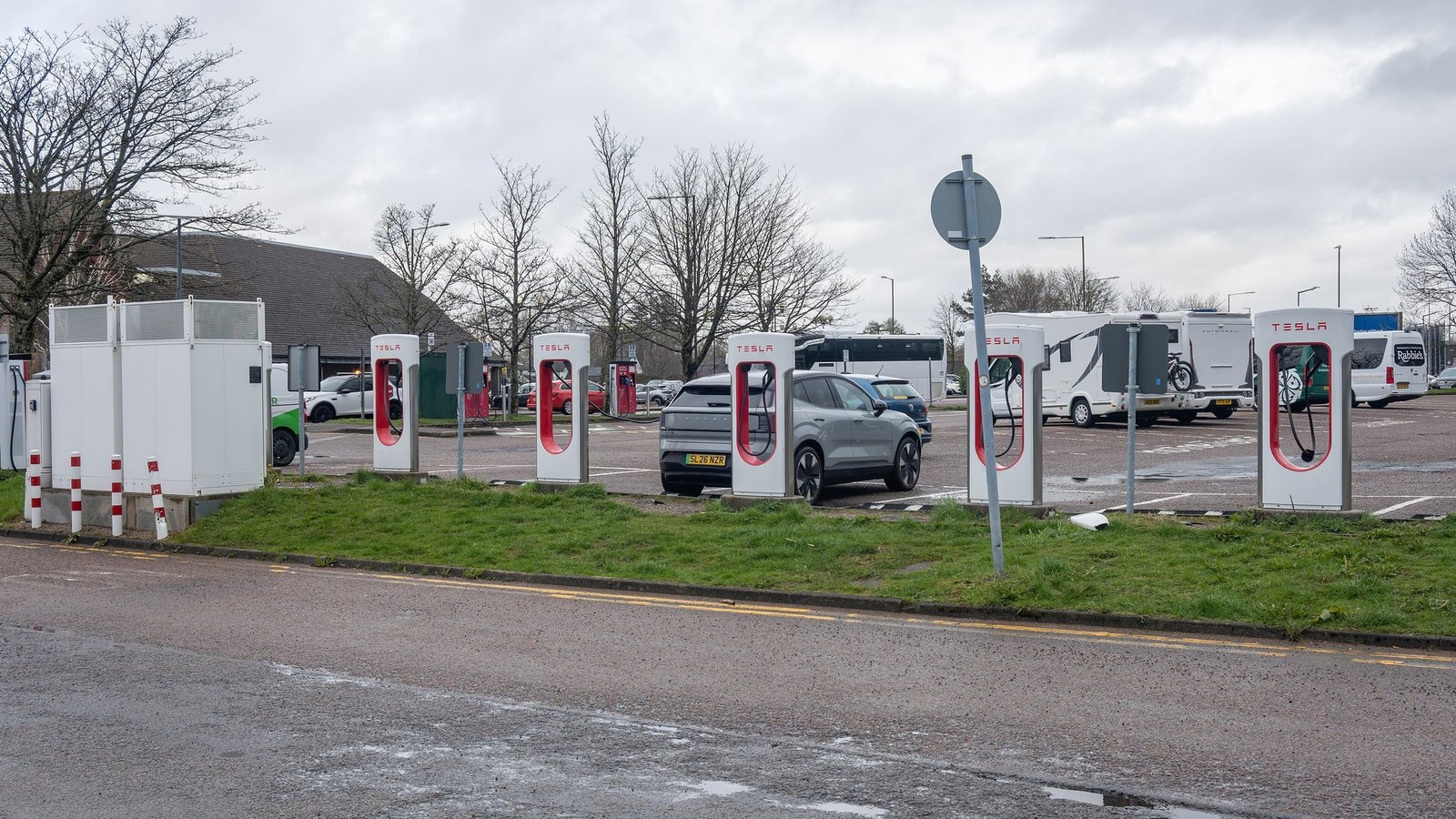 Tesla Superchargers at a charging hub with a car plugged in